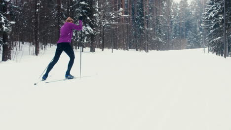 Verfolgung-Einer-Jungen-Erwachsenen-Kaukasischen-Sportlerin-Beim-Skilanglauf-Auf-Einem-Malerischen-Waldweg.-4K-UHD-60 fps-Slo-Mo